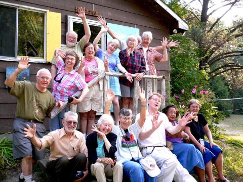 A group of COD camp participants in front of a cabin, waving